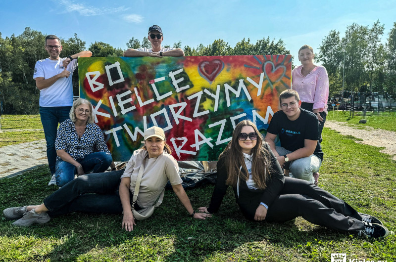 Zdjęcie 7 osób przy dużym banerze z napisem BO KIELCE TWORZYMY RAZEM na kolorowym tle