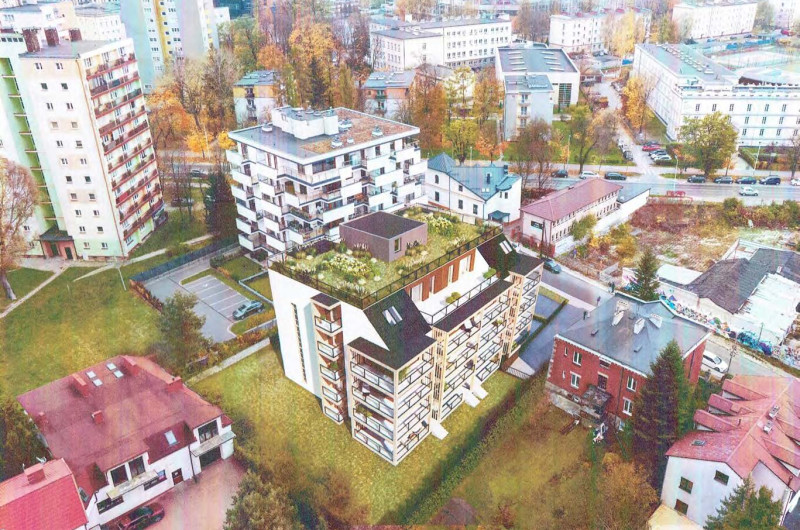 widok z lotu ptaka na budynek wielorodzinny pięciopietrowy z częściowo zielonym dachem